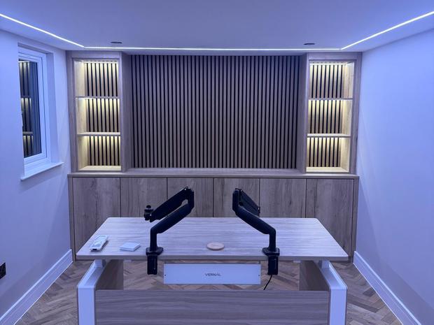 Interior with fitted desk, slatted acoustic wall panel and herringbone flooring